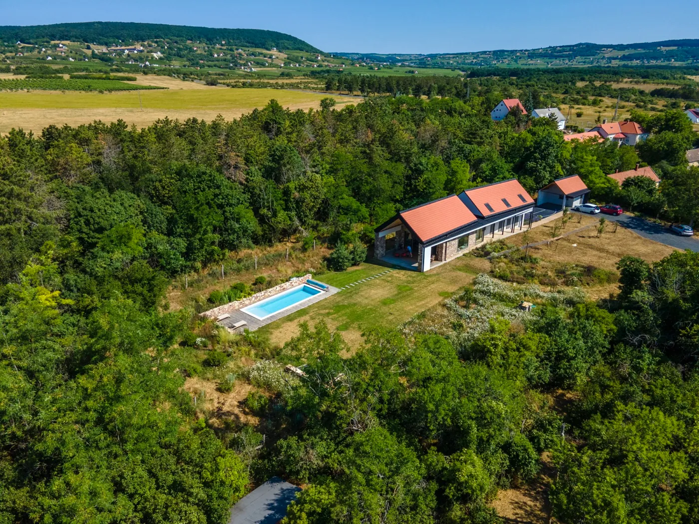 Légifotó a zánkai nyaralóról és kertjéről az erdős platón, háttérben a Balaton-felvidék dombjaival